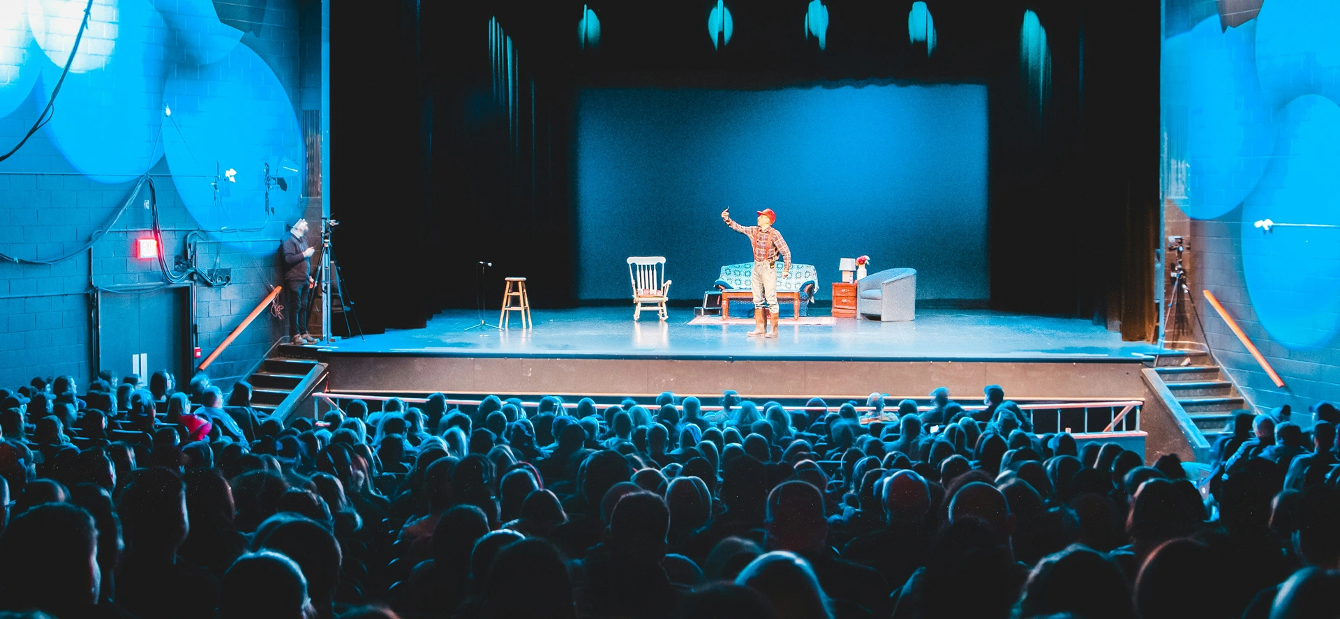 A man is performing on stage in front of an audience.